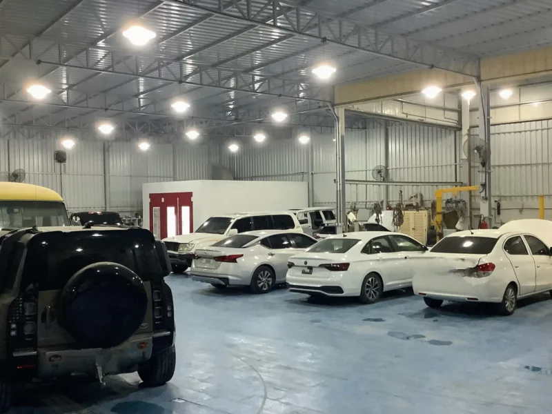 KMP body shop floor with accident-repair vehicles awaiting paint