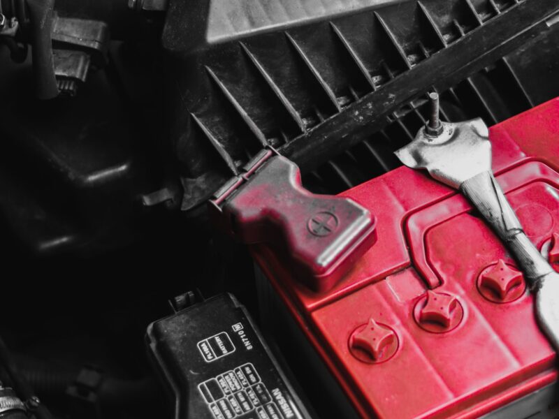 Car battery in an engine bay with a wrench on the terminal