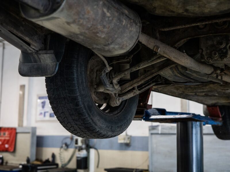 Underside of a car on a lift showing the suspension